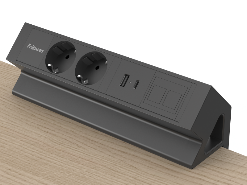 Zwarte opbouwunit met stroomvoorziening. Geklemd op een bureaublad. ZIchtbaar zijn 2 stopcontacten, USB-A/C poort en een keystone-venster