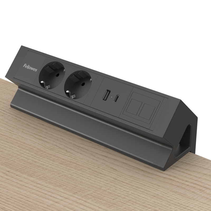Zwarte opbouwunit met stroomvoorziening. Geklemd op een bureaublad. ZIchtbaar zijn 2 stopcontacten, USB-A/C poort en een keystone-venster