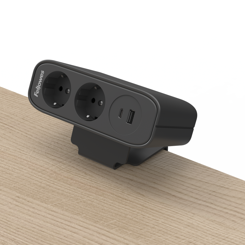 Zwarte stroomunit bevestigd op een bureaublad, zichtbaar zijn twee stopcontacten en een USB-A/C poort